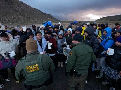 Migrants seeking asylum show their papers to two Border Patrol agents, near Jacumba, California, on February 2.
