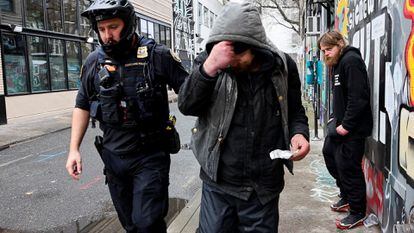 A police officer hands a citation to a fentanyl user in Portland (Oregon), on february 7.
