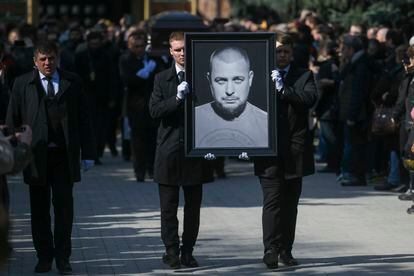 Cemetery workers carry a portrait of slain Russian military blogger Vladlen Tatarsky, during a funeral ceremony on April 8, 2023.