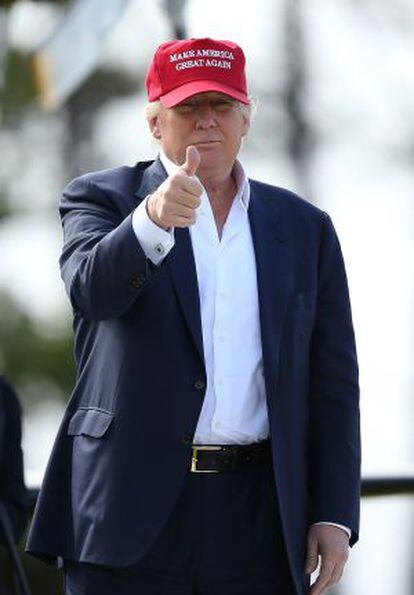 Republican presidential contender Donald Trump gestures to reporters during a golf tournament.