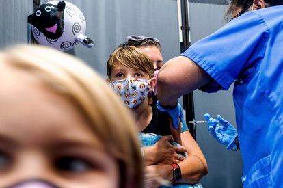 Finn Washburn, 9, receives an injection of the Pfizer-BioNTech COVID-19 vaccine in San Jose, Calif., on Nov. 3, 2021, as his sister, Piper Washburn, 6, waits her turn. California's COVID-19 emergency declaration ends on Tuesday, Feb. 28, 2023.