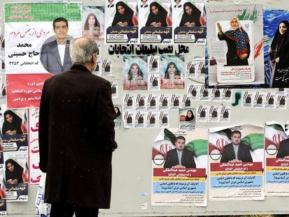 A man looks at election posters of candidates running in the Iranian parliamentary elections, on Monday in Tehran.