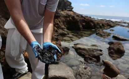 A volunteer clears up fuel oil on a beach in Mogán, Gran Canaria on Saturday.