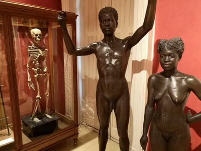 The skeleton of a Filipina woman at the National Museum of Anthropology in Madrid, next to two 19th-century statues of people from Equatorial Guinea. 