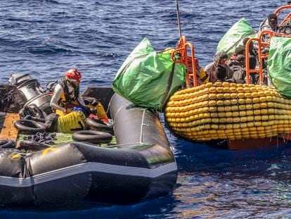 A migrant is helped evacuate a partially deflated rubber dinghy by the rescue personnel of the SOS Mediterranee humanitarian ship Ocean Viking in the Central Mediterranean Sea, March 13, 2024.