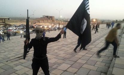 A militant raises an Islamic State flag after the fall of Mosul in June 2014.
