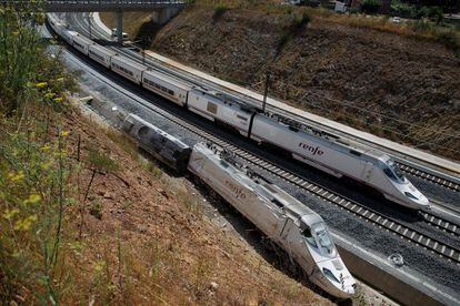 An Alvia train passes the wreckage of the Santiago crash.