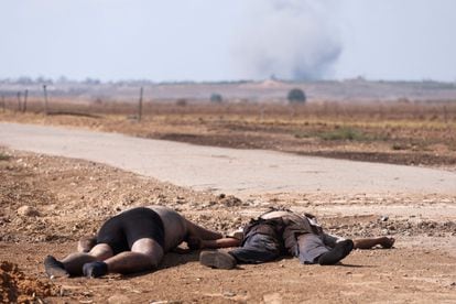 Two bodies lay on the ground near a road in Kfar Aza, south of Israel bordering Gaza Strip, on October 10, 2023, following fighting between Israeli forces and Palestinian militants. 