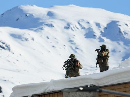 Police officers stand watch from the roof of a building in Davos on Monday.