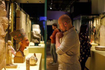 A man looks at an Egyptian bust in the exhibition.