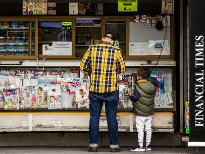 A man with his son at a newsstand by La Paz hospital, in Madrid.