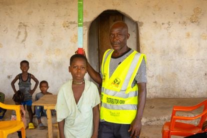 Abraham Kallie, 45, is a health volunteer in his community in Febe, Bong County (northern Liberia). With a 1.8-meter colored stick, he calculates the dose of medicine each child should receive to prevent parasitic diseases.