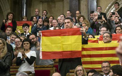 PP deputies hold up Spanish and Catalan flags after the vote.