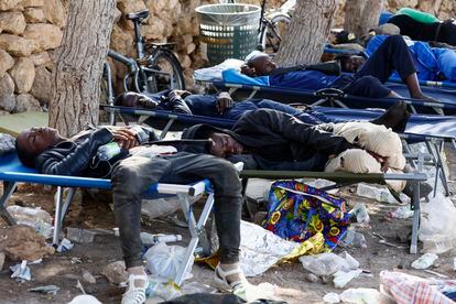 Several people rest on deck chairs placed outside the reception center on the Italian island of Lampedusa on Friday.