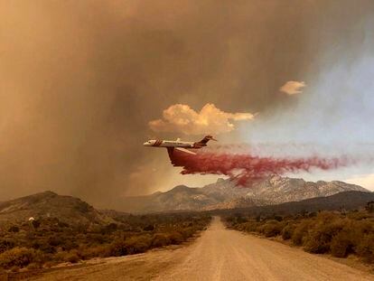This photo provided by the National Park Service Mojave National Preserve shows a tanker making a fire retardant drop over the York fire in Mojave National Preserve on Saturday, July 29, 2023. A massive wildfire burning out of control in California's Mojave National Preserve is spreading rapidly amid erratic winds. Meanwhile, firefighters reported some progress Sunday against another major blaze to the southwest that prompted evacuations. (Park Ranger R. Almendinger/ InciWeb /National Park Service Mojave National Preserve via AP)