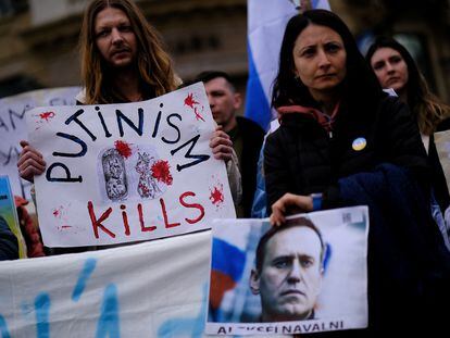People hold a banner and a image of late Russian opposition leader Alexei Navalny on his memorial at Las Ramblas of Barcelona, Spain, February 25, 2024.