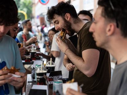 People eating hamburgers at a festival in Milan, Italy.