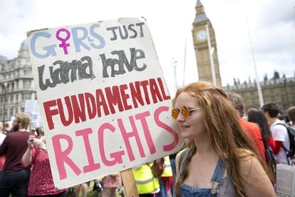 A demonstrator holds a banner reading "Girls Just Wanna Have Fundamental Rights" at a rally in London in 2017. 