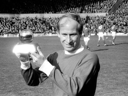 Manchester United's Bobby Charlton lifts the 1966 European Footballer of the Year trophy.