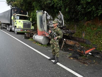 A soldier stands guard next to a truck burned by members of the Clan del Golfo cartel in Antioquia, Colombia, on May 6, 2022.