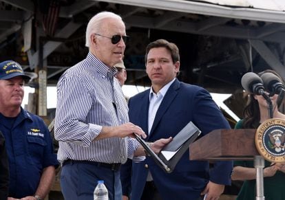 US President Joe Biden arrives to speak in a neighborhood impacted by Hurricane Ian on October 5, 2022, as Florida Governor Ron DeSantis looks on. 