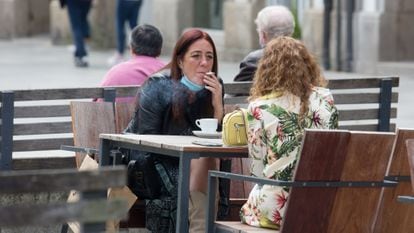 A woman smokes at a sidewalk cafe in Galicia, which has banned smoking in all public spaces when social distancing measures cannot be respected.