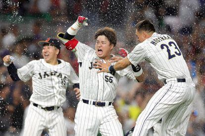 Munetaka Murakami #55 of Team Japan celebrates with teammates after hitting a two-run double to defeat Team Mexico