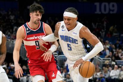 Orlando Magic's Paolo Banchero (5) drives to the basket against Washington Wizards' Deni Avdija (9) during the first half of an NBA basketball game, Tuesday, March 21, 2023, in Orlando, Fla.