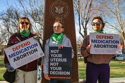Three members of the Women's March group protest in support of access to abortion medication outside the Federal Courthouse on March 15, 2023 in Amarillo, Texas.