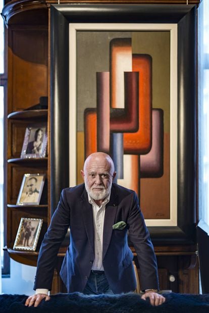 Roberto Polo standing before a painting by Pierre-Louis Flouquet.