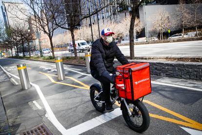 In this March 16, 2020 file photo, a delivery worker rides his bicycle along a path on the West Side Highway in New York.
