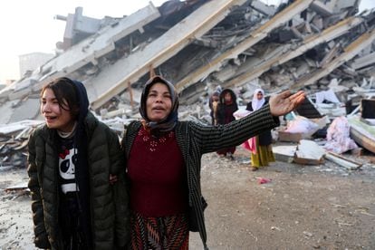 Women react near rubble following an earthquake in Hatay, Turkey.