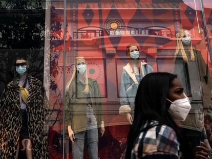 A shopper walks past mannequins donning face masks in Los Angeles, on Dec. 7, 2020.
