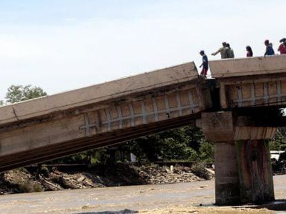 Survivors trying to cross a bridge in Coyuca de Ben&iacute;tez (Guerrero).