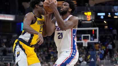 Philadelphia 76ers center Joel Embiid, right, moves against Indiana Pacers forward Serge Ibaka during the first half of an NBA basketball game in Indianapolis, Saturday, March 18, 2023.