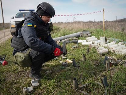 A sapper of the Ukrainian State Emergency Service collects remains of shells, grenades and other devices at the demining site near village of Kamenka, Kharkiv region, Ukraine, on April 11, 2023.