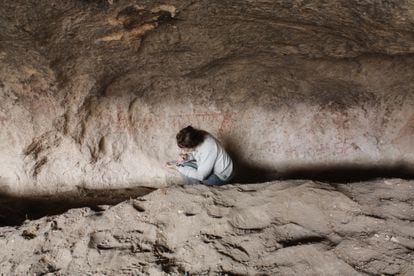 Archaeologist Guadalupe Romero Villanueva documents paintings in the Huenul 1 cave in Argentina's Patagonia region.