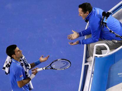 Novak Djokovic of Serbia, left, talks with chair umpire Jake Garner of the U.S. as he plays Andy Murray of Britain during the men's singles final at the Australian Open tennis championship in Melbourne, Australia, Sunday, Feb. 1, 2015.