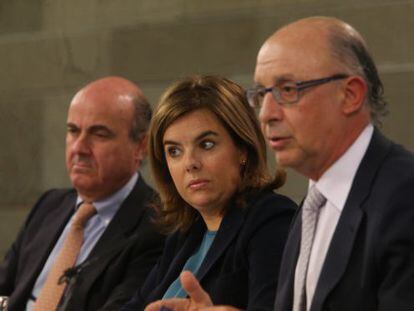 Economy Minister Luis de Guindos, Deputy PM Soraya S&aacute;enz de Santamar&iacute;a and Finance Minister Crist&oacute;bal Montoro speak to the press on Friday. 