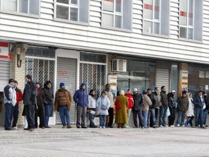People stand in line outside an employment office.
