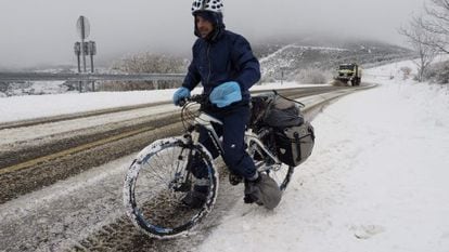 A cyclist tries to negotiate snowy roads in Lugo province.
