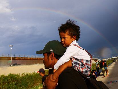 A man carries his son while seeking asylum in the United States, on the banks of the Rio Bravo river, on September 12, 2023.