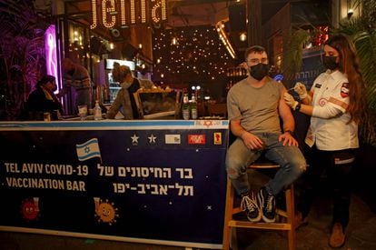 A health worker administers a Covid vaccine in a bar in Tel Aviv.