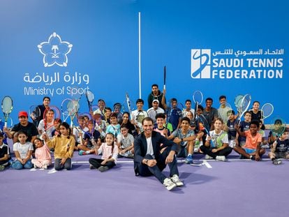 Nadal poses with a group of children at the Mahd Academy in Riyadh on December 10.