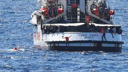 Migrants jump from the ‘Open Arms’ into the sea.