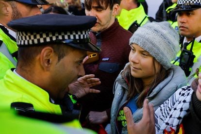 A police officer speaks to Swedish climate campaigner Greta Thunberg during an Oily Money Out and Fossil Free London protest in London, October 17, 2023.