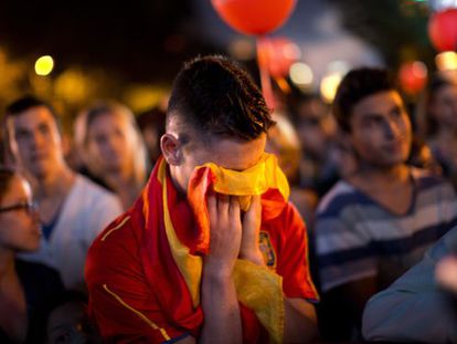 A man covers his face with a Spanish flag in Madrid&#039;s Puerta de Alcal&aacute; on Saturday night, after hearing the news that the city&#039;s bid to host the 2020 Olympics had failed.
