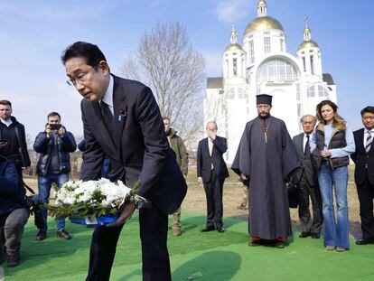 Japanese Prime Minister Fumio Kishida, front, lays the flowers at a church in Bucha, a town outside Kyiv that became a symbol of Russian atrocities against civilians, on March 21, 2023.