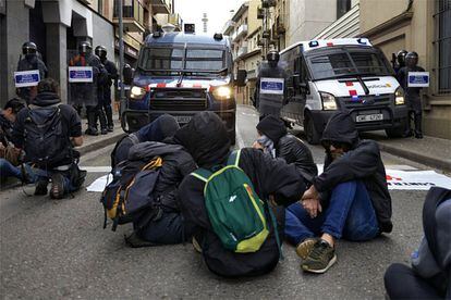 Protesters sit in front of a Catalan regional police station in Girona on the fifth day of protests against the Supreme Court ruling that sentenced nine separatist leaders to prison.