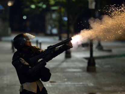 A member of the National Police shoots tear gas during clashes with anti-government demonstrators in Caracas Monday night.